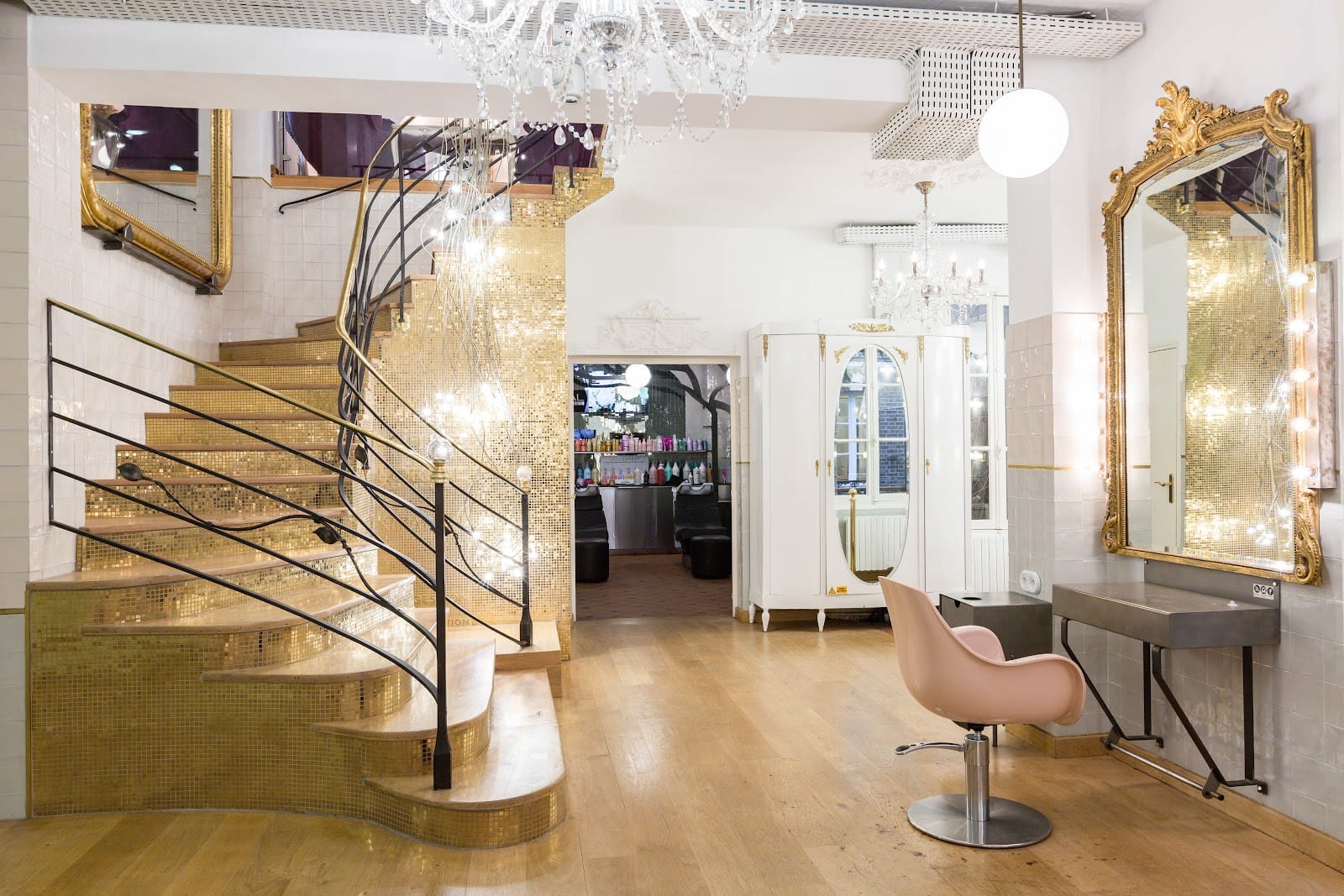 L’atelier : escalier de mosaïque dorée, lustre de cristal, miroir rocaille et fauteuil rose